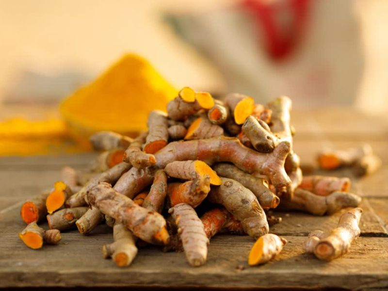 komadi kurkume i mlevena kurkuma na drvenom stolu