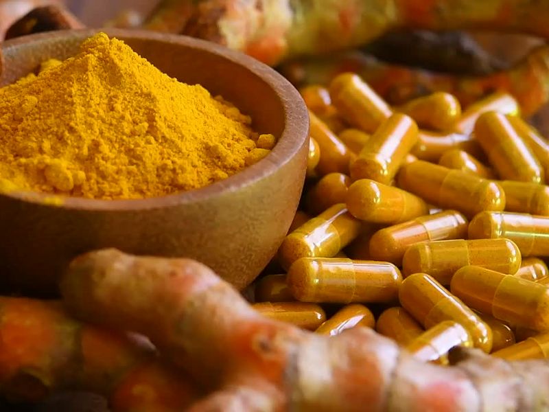 prikaz komada kurkume, kurkume u prahu i kapsula pored