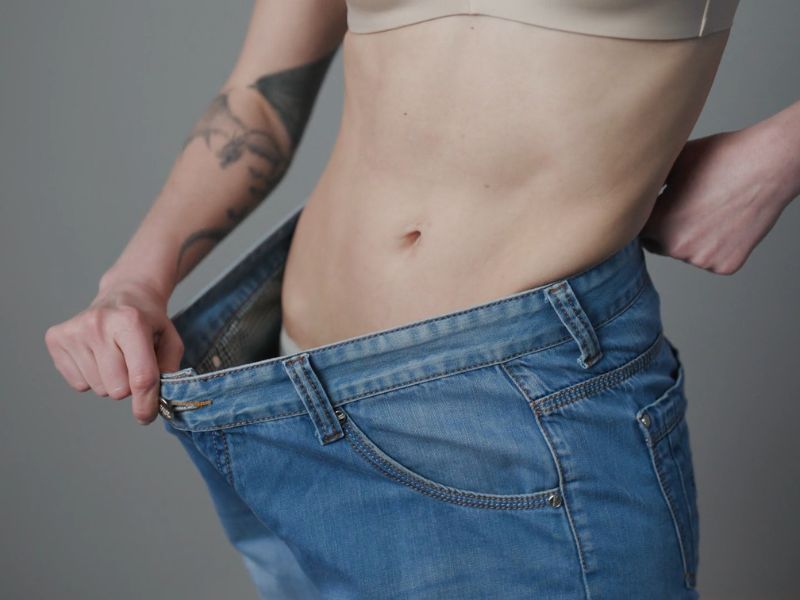 devojka sa ravnim stomakom pokazuje koliko je smanjila nadutost u stomaku